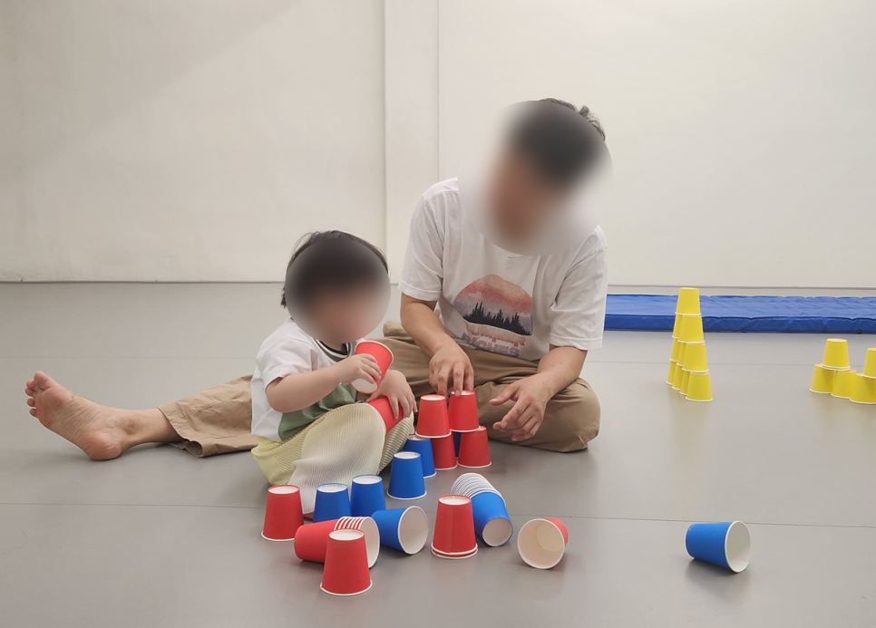 컵 쌓기 놀이를 하는 아이와 선생님